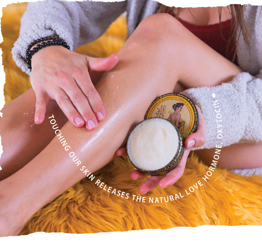 Banner of a woman applying Barefoot Venus Muscle Rub to her legs. Text in a wave across the image reads "Touching our skin releases the natural love hormone, oxytocin".