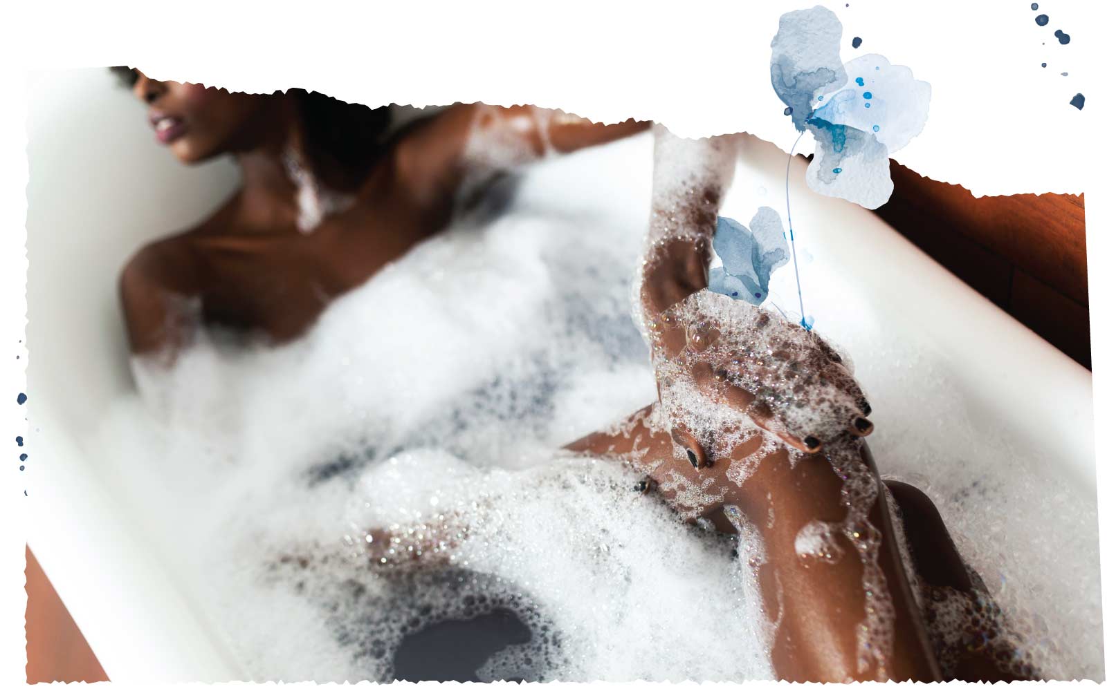 Woman in bathtub covered in bubbles.