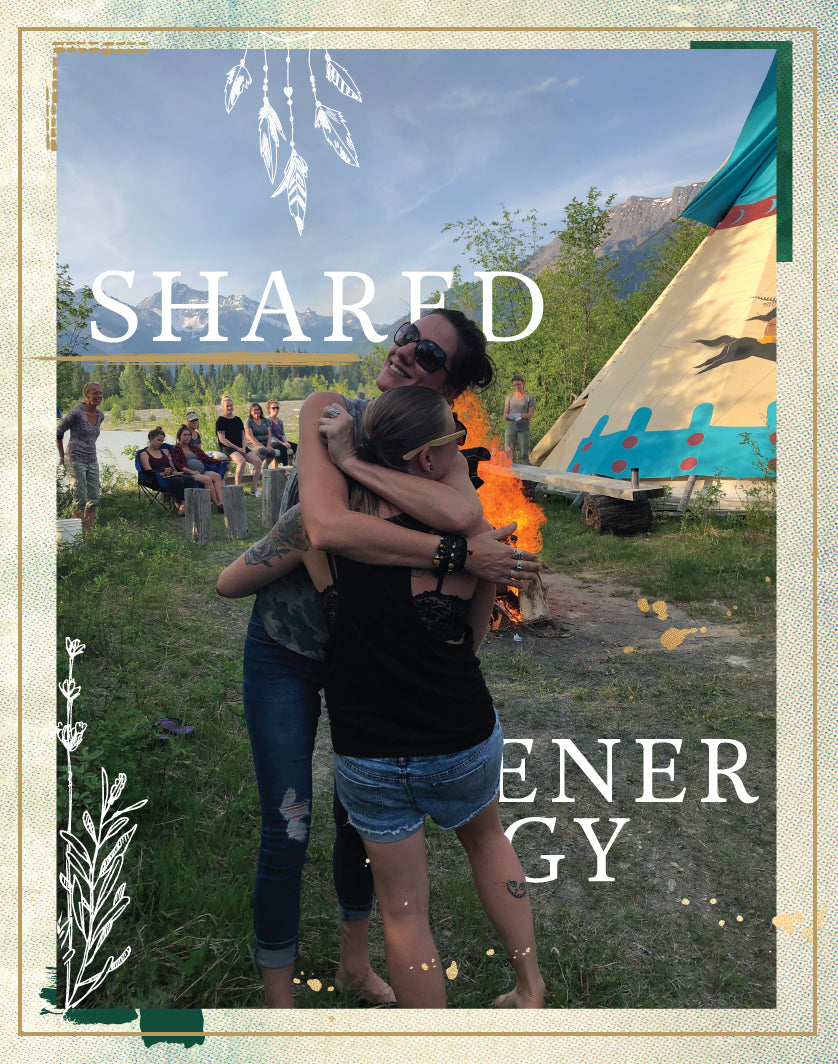 Two women hugging in the forest with a decorative frame and leafy, flower graphic overlay. Text reads "Shared Energy".